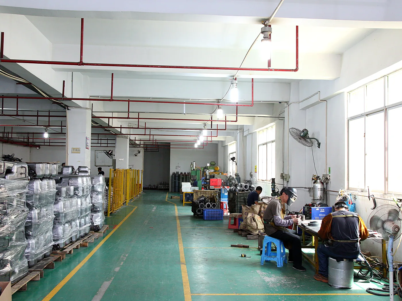 Assembly hall seen down its length, racks of parts along the left
