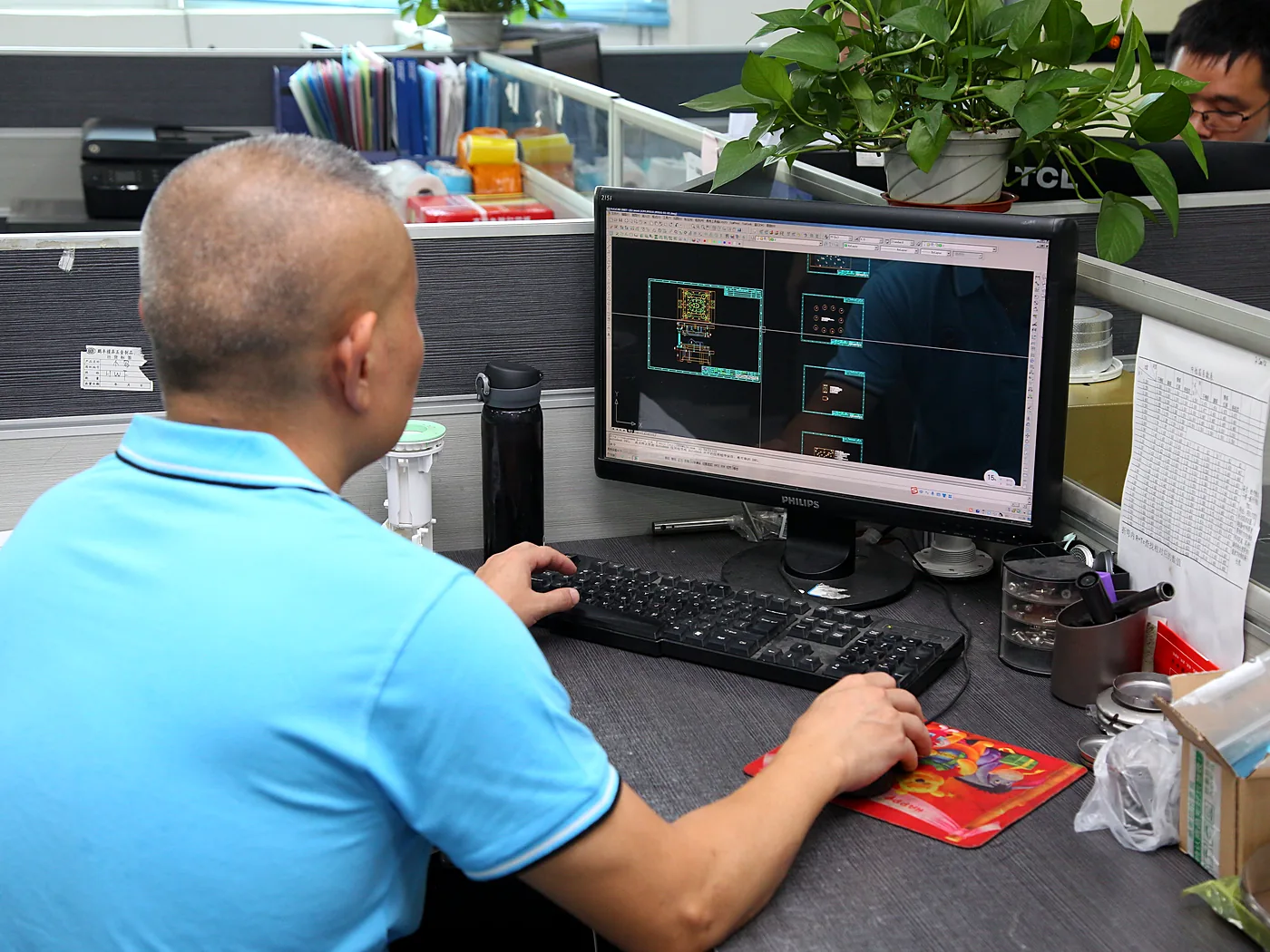 Engineer reading a CAD drawing on a monitor
