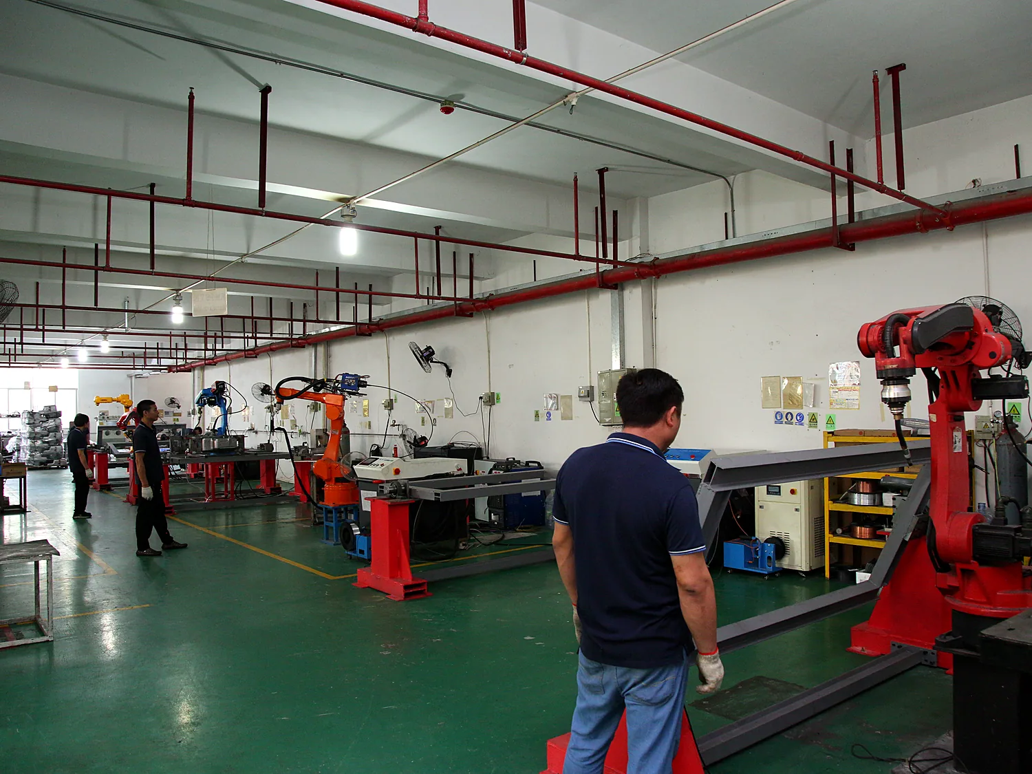 Row of orange robotic welding stations along the line