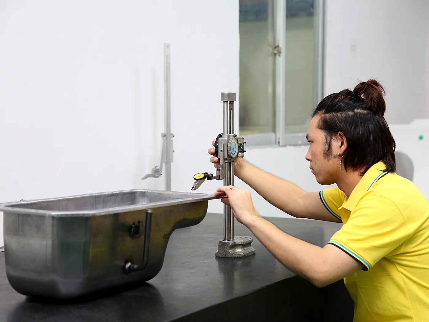Technician measuring a part on an inspection bench