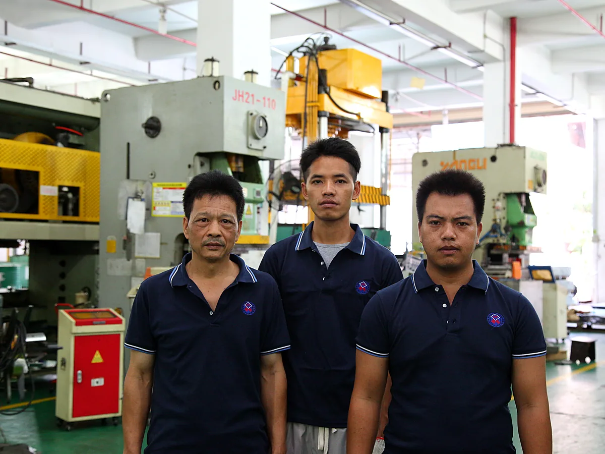 Three staff beside a machine tool