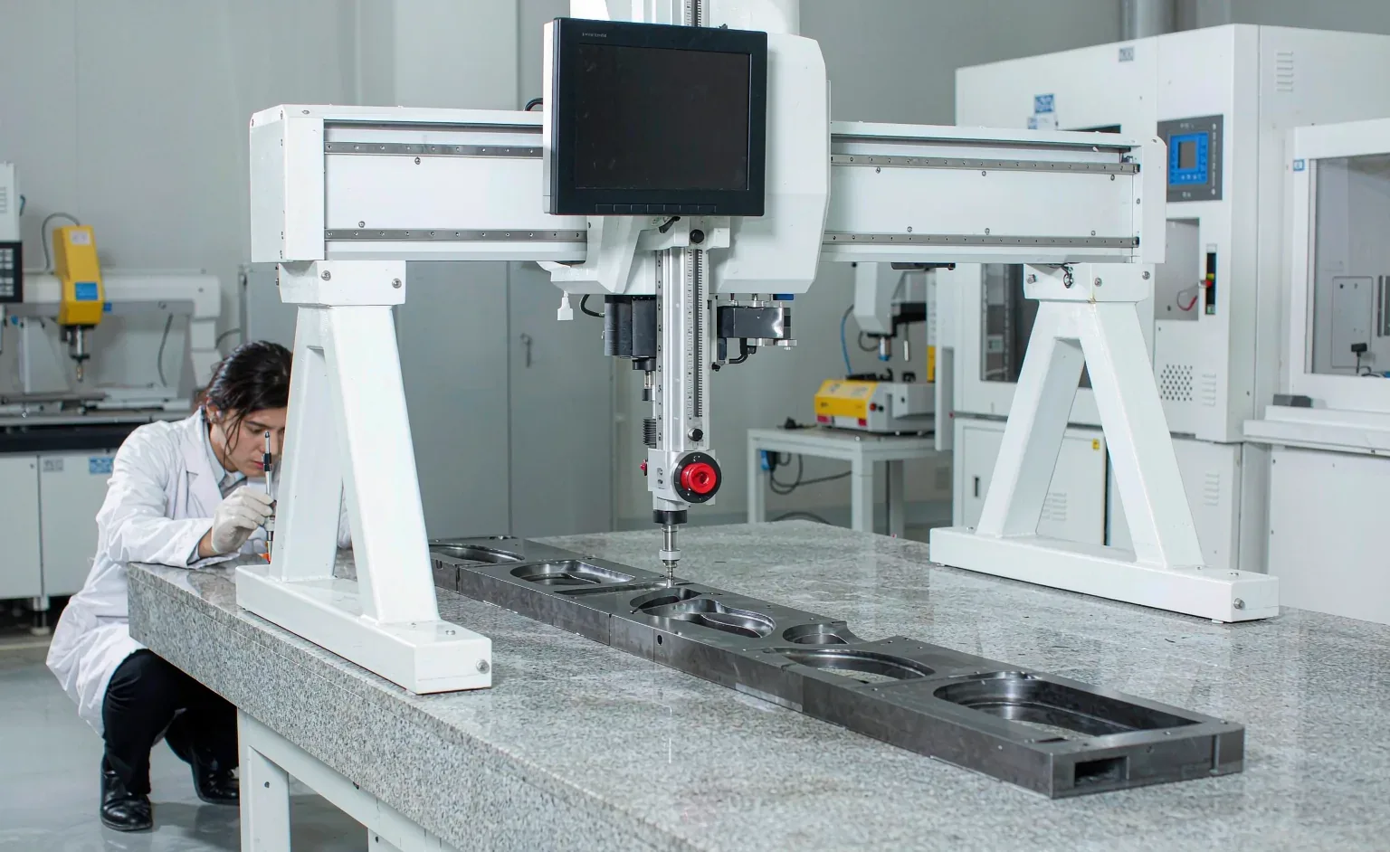 Bridge-type coordinate measuring machine measuring a precision aluminium part